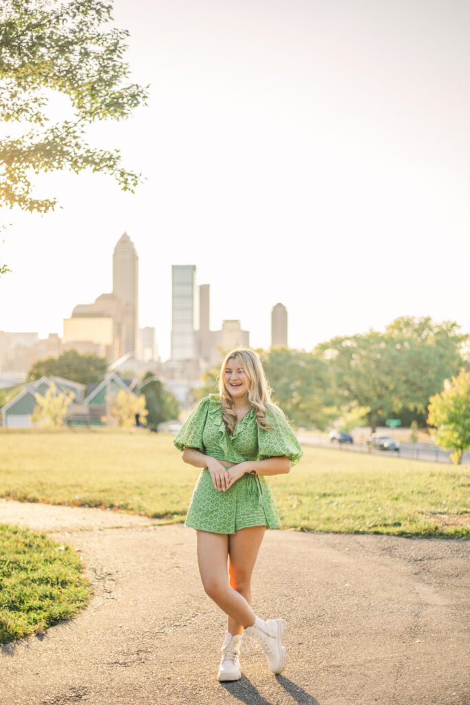 Joyful high school senior girl laughing in a cute green outfit at Highland Park in Indianapolis, Indiana