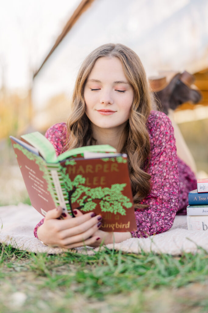 High School senior holding books during personalized senior photo session. 