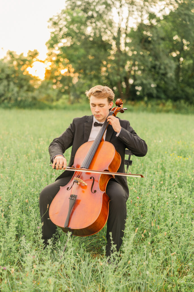 Senior boy holding a cello prop for personalized senior portrait session